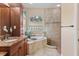 Bathroom featuring dark wood cabinets, a soaking tub, and a glass-enclosed shower at 6951 Scrub Jay Dr, Sarasota, FL 34241