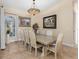 Traditional dining room features decorative lighting, neutral walls, and ample seating for eight at 6951 Scrub Jay Dr, Sarasota, FL 34241