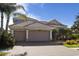 Charming home exterior with a tile roof, lush tropical landscaping, and a spacious brick driveway at 6951 Scrub Jay Dr, Sarasota, FL 34241