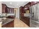 Modern kitchen with stainless steel appliances, granite countertops, and rich wood cabinetry at 6951 Scrub Jay Dr, Sarasota, FL 34241