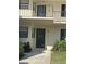 Inviting condo entrance with a modern black front door, a well-maintained walkway, and pretty landscaping at 7050 Fairway Bend Ln # 167, Sarasota, FL 34243