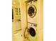 A compact laundry area featuring a stacked washer and dryer unit at 7050 Fairway Bend Ln # 167, Sarasota, FL 34243