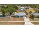 Aerial view of a blue single-story home with a large fenced yard, surrounded by mature trees at 7055 Kenwood Dr, North Port, FL 34287