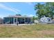 Backyard view of a screened-in porch and shed on an expansive lawn at 7055 Kenwood Dr, North Port, FL 34287