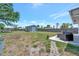 Large, grassy backyard with a shed, utility trailer and privacy fence at 7055 Kenwood Dr, North Port, FL 34287