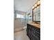 Bright bathroom featuring a glass shower, a large mirror, and a modern vanity with gold accents at 7055 Kenwood Dr, North Port, FL 34287