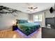 Stylishly decorated bedroom with a modern floating bed, unique lighting, and hardwood floors at 7055 Kenwood Dr, North Port, FL 34287