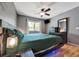 Well-lit bedroom with a modern ceiling fan, large window, and sleek, matching furniture at 7055 Kenwood Dr, North Port, FL 34287
