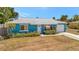 Charming blue single-story home with a well-kept lawn and attached garage at 7055 Kenwood Dr, North Port, FL 34287