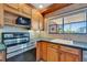 Bright kitchen area features stainless steel stove, wood cabinets and tile backsplash at 7055 Kenwood Dr, North Port, FL 34287
