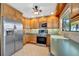 Traditional kitchen features stainless steel appliances, wood cabinets, and tile flooring at 7055 Kenwood Dr, North Port, FL 34287