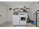 Functional laundry room featuring modern washer and dryer, plus shelving for organizing cleaning supplies at 7055 Kenwood Dr, North Port, FL 34287