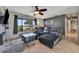 Cozy living room with a comfortable leather sectional, natural light, and a modern ceiling fan at 7055 Kenwood Dr, North Port, FL 34287