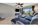 Well lit living room featuring TV, modern fireplace, large window and comfortable seating at 7055 Kenwood Dr, North Port, FL 34287