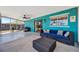 Screened patio boasts stylish furniture, ceiling fan, and a bright turquoise accent wall at 7055 Kenwood Dr, North Port, FL 34287
