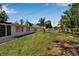 Backyard showcasing the lawn, partial fencing, and the exterior of the home with windows and a screened porch at 709 84Th Nw St, Bradenton, FL 34209