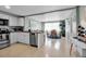 The kitchen features white cabinetry, stainless steel appliances, granite countertops, and is open to the dining area at 709 84Th Nw St, Bradenton, FL 34209