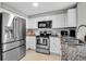 Kitchen boasts granite countertops, stainless steel appliances, white cabinets, and tiled backsplash at 709 84Th Nw St, Bradenton, FL 34209