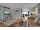 Bright living room featuring a cozy seating area, stylish rug, and open layout to kitchen at 709 84Th Nw St, Bradenton, FL 34209