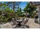 Outdoor patio featuring a modern fire pit table with seating and gas grill, surrounded by lush landscaping at 709 84Th Nw St, Bradenton, FL 34209