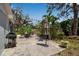 Outdoor patio with gas grill, umbrella, and seating area surrounded by mature trees and landscaping at 709 84Th Nw St, Bradenton, FL 34209