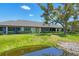 Well-maintained backyard with a pond, lush green lawn, and manicured hedges at 7374 Royal Birkdale Dr # 15D, Sarasota, FL 34238