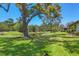 Expansive backyard with a picturesque pond and mature trees in the distance at 7374 Royal Birkdale Dr # 15D, Sarasota, FL 34238