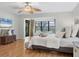 Bright bedroom features hardwood floors, a decorative ceiling fan, and large windows letting in natural light at 7374 Royal Birkdale Dr # 15D, Sarasota, FL 34238