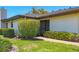 Exterior shot of a home featuring a screened entryway, lush green lawn, and neat hedges at 7374 Royal Birkdale Dr # 15D, Sarasota, FL 34238