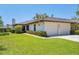 Charming home with an attached two-car garage, manicured lawn, and green landscaping at 7374 Royal Birkdale Dr # 15D, Sarasota, FL 34238