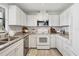 Galley kitchen featuring white appliances, white cabinets, and updated countertops at 7374 Royal Birkdale Dr # 15D, Sarasota, FL 34238