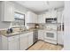 Bright kitchen featuring white appliances, cabinets, stainless dishwasher, and granite countertops at 7374 Royal Birkdale Dr # 15D, Sarasota, FL 34238