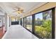 Bright sunroom with tile floors, ceiling fans and many windows showcasing lush outdoor views at 7374 Royal Birkdale Dr # 15D, Sarasota, FL 34238