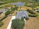 Aerial view of a home with a large yard and long driveway, backing up to a serene pond at 8121 Snowy Egret Pl, Bradenton, FL 34202