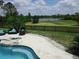 Backyard oasis with a rock waterfall feature flowing into a sparkling pool, with lake views at 8121 Snowy Egret Pl, Bradenton, FL 34202
