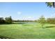 Expansive backyard with lush green grass leading to a tranquil lake, creating a serene outdoor space at 8121 Snowy Egret Pl, Bradenton, FL 34202