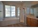 Bright bathroom featuring a garden tub with wood-look floors and a glass shower at 8121 Snowy Egret Pl, Bradenton, FL 34202
