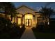 Stunning home with a beautifully lit entryway and lush landscaping, creating a warm and inviting ambiance at 8121 Snowy Egret Pl, Bradenton, FL 34202