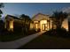 Elegant home with a grand entrance and professionally designed landscaping, creating a stunning nighttime view at 8121 Snowy Egret Pl, Bradenton, FL 34202