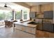 Modern kitchen with stainless steel appliances, gray cabinets, and stone-look backsplash and dining area at 8121 Snowy Egret Pl, Bradenton, FL 34202