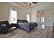 Bright main bedroom featuring a tray ceiling, a ceiling fan, and wood-look flooring at 8121 Snowy Egret Pl, Bradenton, FL 34202