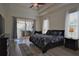 Bright primary bedroom featuring access to the lanai, wood-look floors, and a ceiling fan at 8121 Snowy Egret Pl, Bradenton, FL 34202