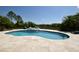 Backyard view featuring a pool area, waterfall, and lush landscaping at 8121 Snowy Egret Pl, Bradenton, FL 34202