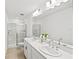 Bathroom features a double sink vanity, large mirror, and a shower with glass door at 8545 Daybreak St, Sarasota, FL 34241