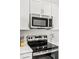 Close-up view of the kitchen's stainless steel microwave and electric range at 8545 Daybreak St, Sarasota, FL 34241