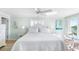 Bright main bedroom featuring a king bed, white furniture and fixtures, and views of the water and outdoor pool at 8911 Midnight Pass Rd # 308, Sarasota, FL 34242