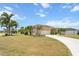 Beautiful single-story home featuring a two car garage, manicured lawn, and lush tropical landscaping at 9012 Province St, Sarasota, FL 34240