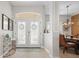 Inviting foyer features double doors, light wood flooring, and an elegant chandelier over the dining area at 9012 Province St, Sarasota, FL 34240