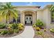 Charming front entry with double doors, decorative wreaths, and meticulously landscaped flower beds at 9012 Province St, Sarasota, FL 34240