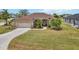 Well-maintained single-story home with a manicured lawn, a two-car garage, and beautiful landscaping at 9012 Province St, Sarasota, FL 34240